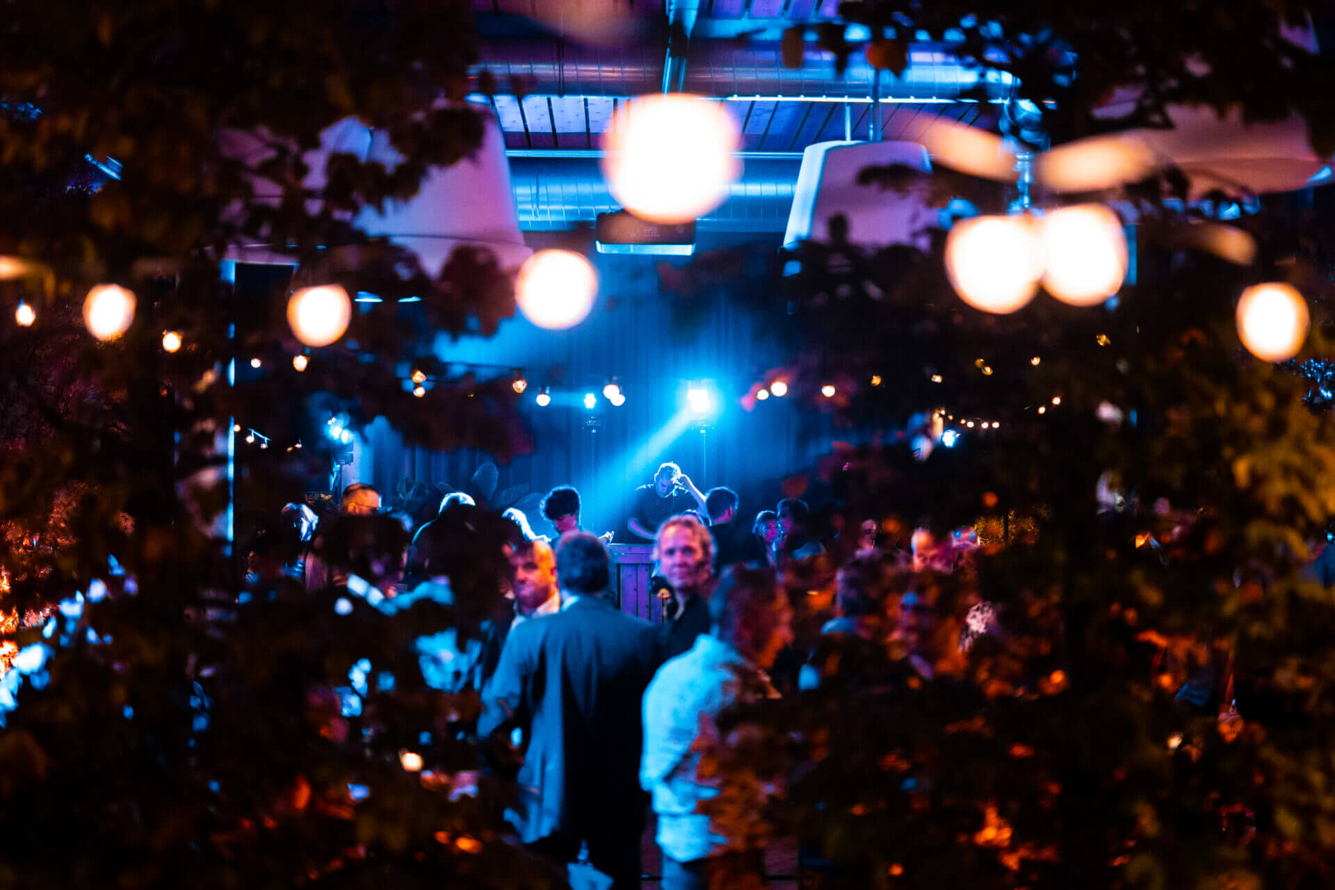 Publiek danst in zaal met bomen